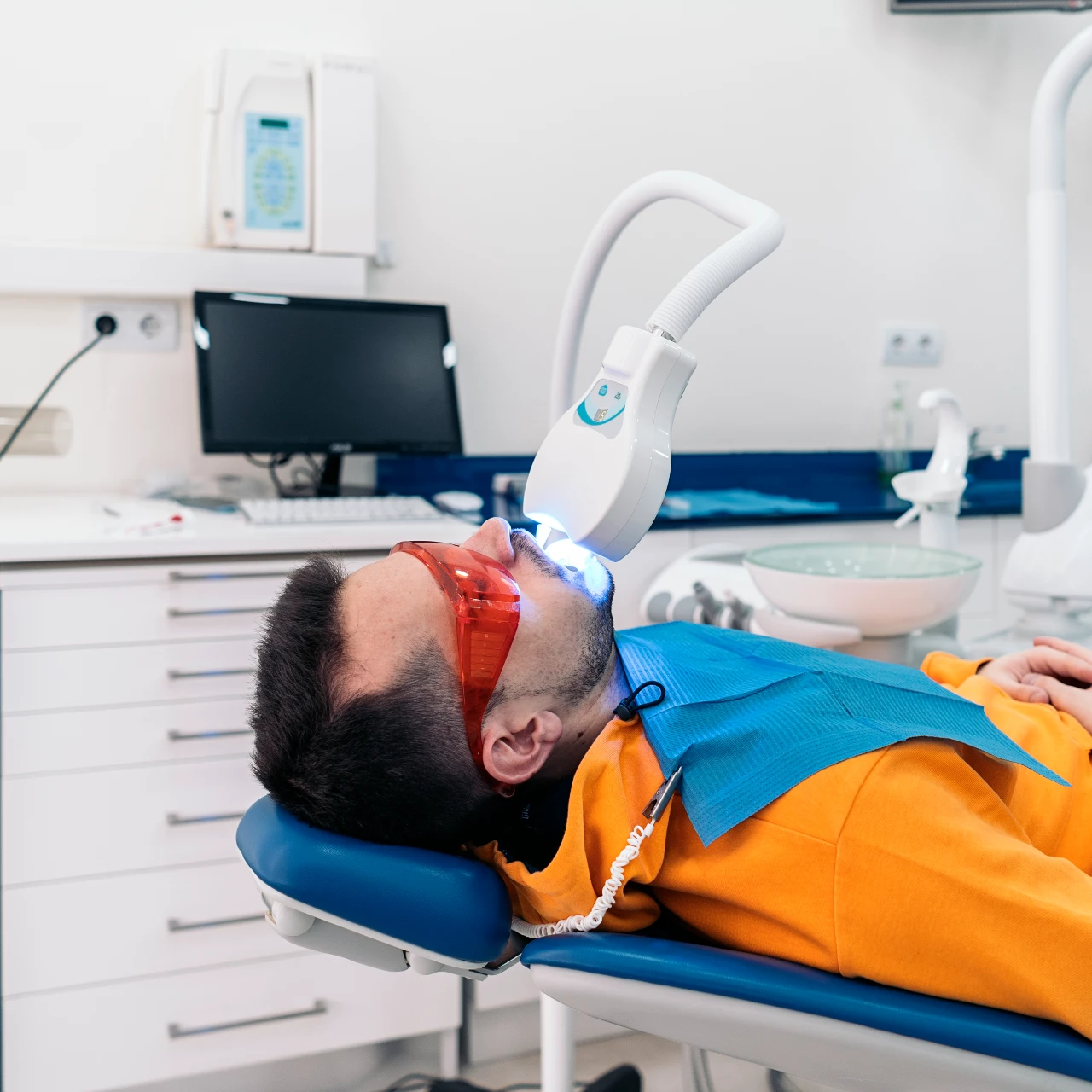 man doing professional teeth whitening at the dentist office | teeth whitening orange county