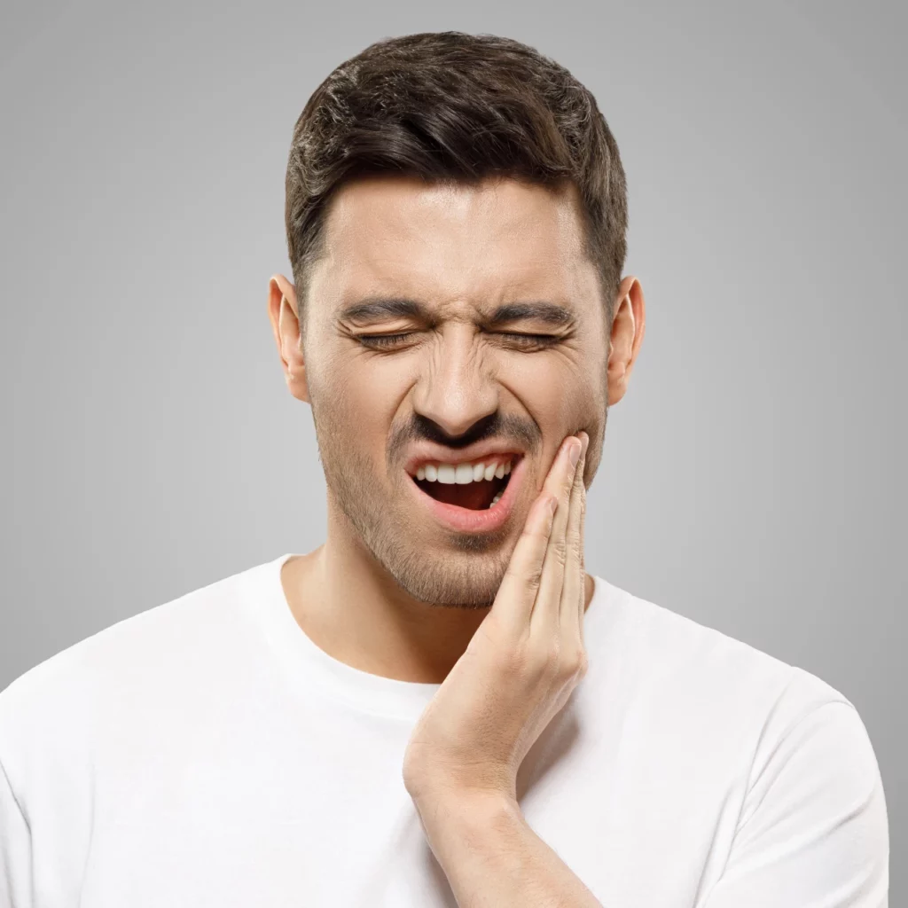 Man rubbing his jaw in pain needing TMJ treatment